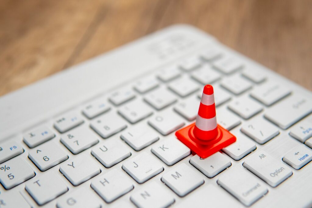A miniature traffic cone placed on a computer keyboard
