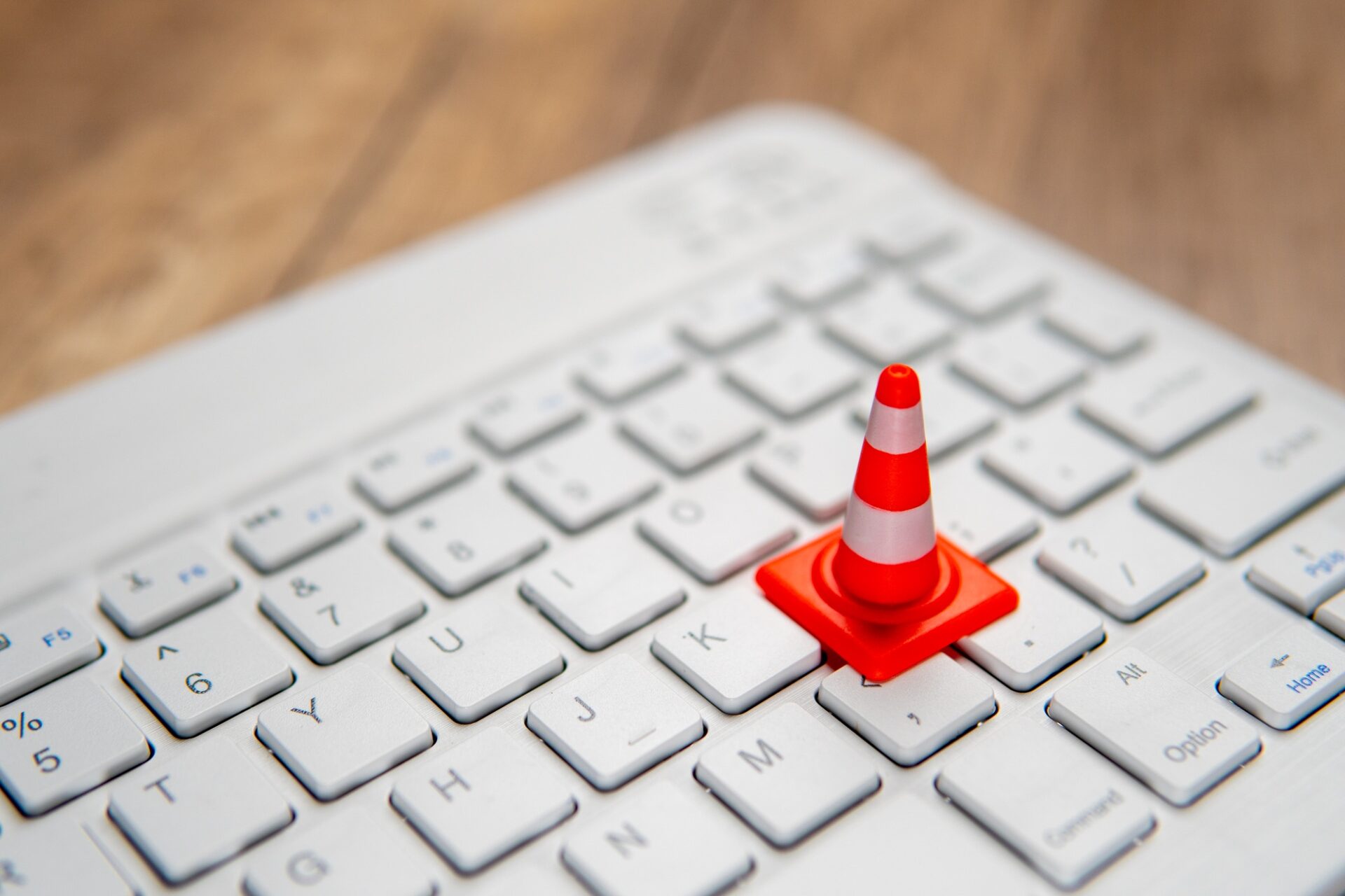 A miniature traffic cone placed on a computer keyboard